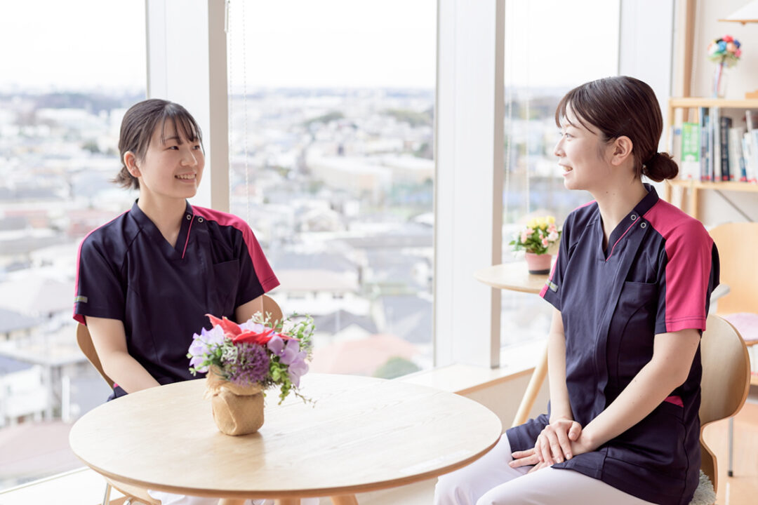 2名の看護師が椅子に座ってリラックスした様子で会話している様子